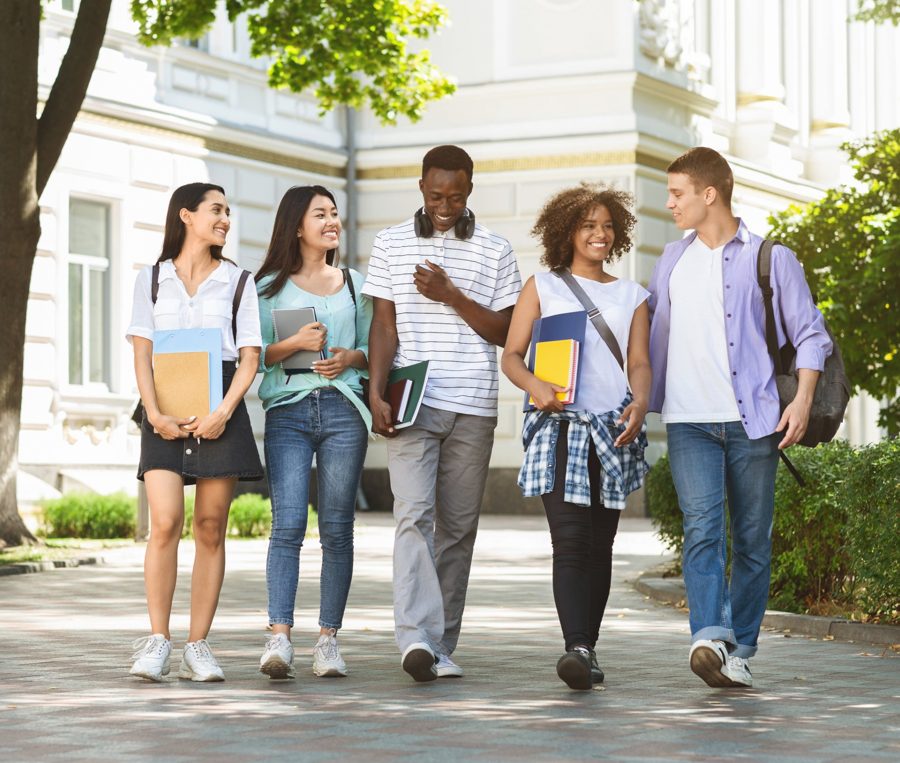 Grupo de estudantes de várias nacionalidades caminhando juntos no campus