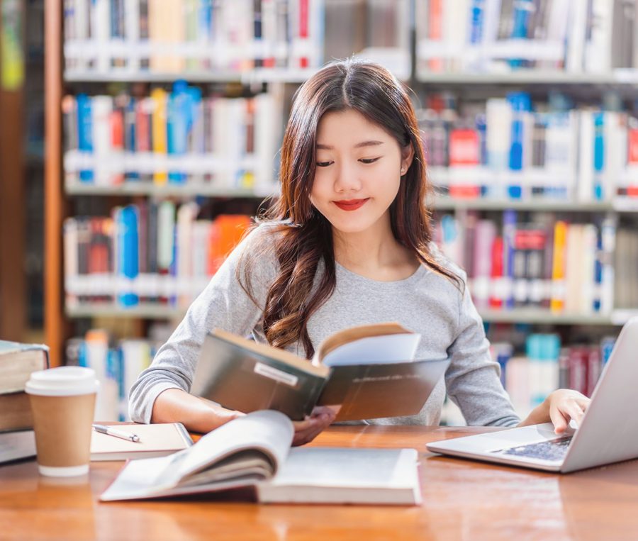 Estudante lendo um livro numa biblioteca